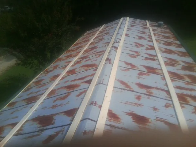 Rusted metal roof panels with new wood purlins before replacement — Storm Damage Roof Repair in Medford by Roofing Brothers