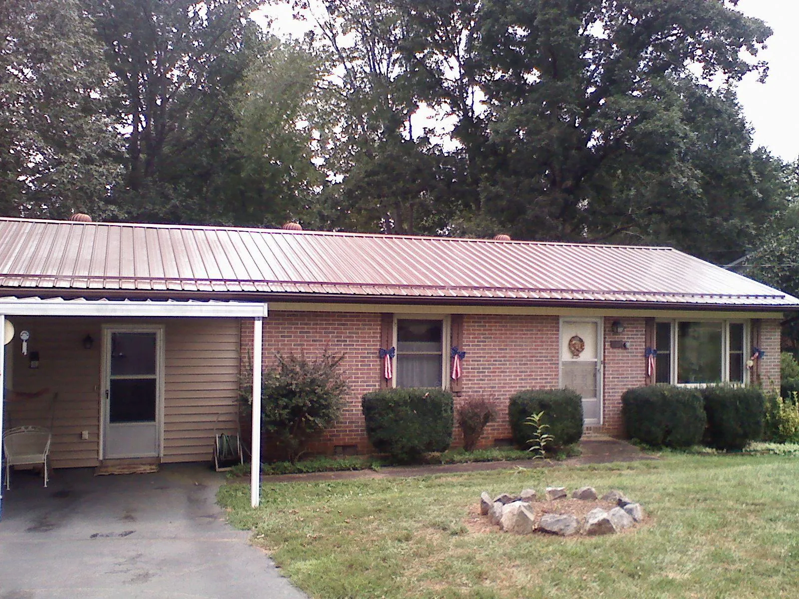 Bronze metal roof and carport on a brick ranch home — Roof Repair work by our crew in Medford