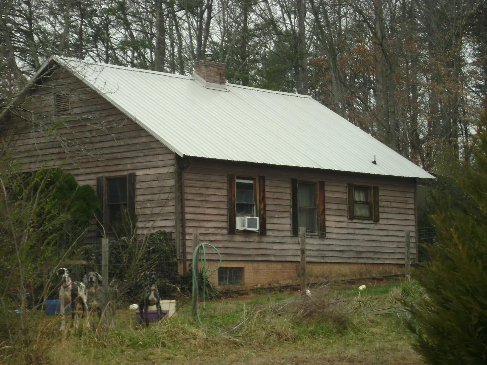 White metal roof on an old wood sided farmhouse, from a Metal Roof Installation job in Medford